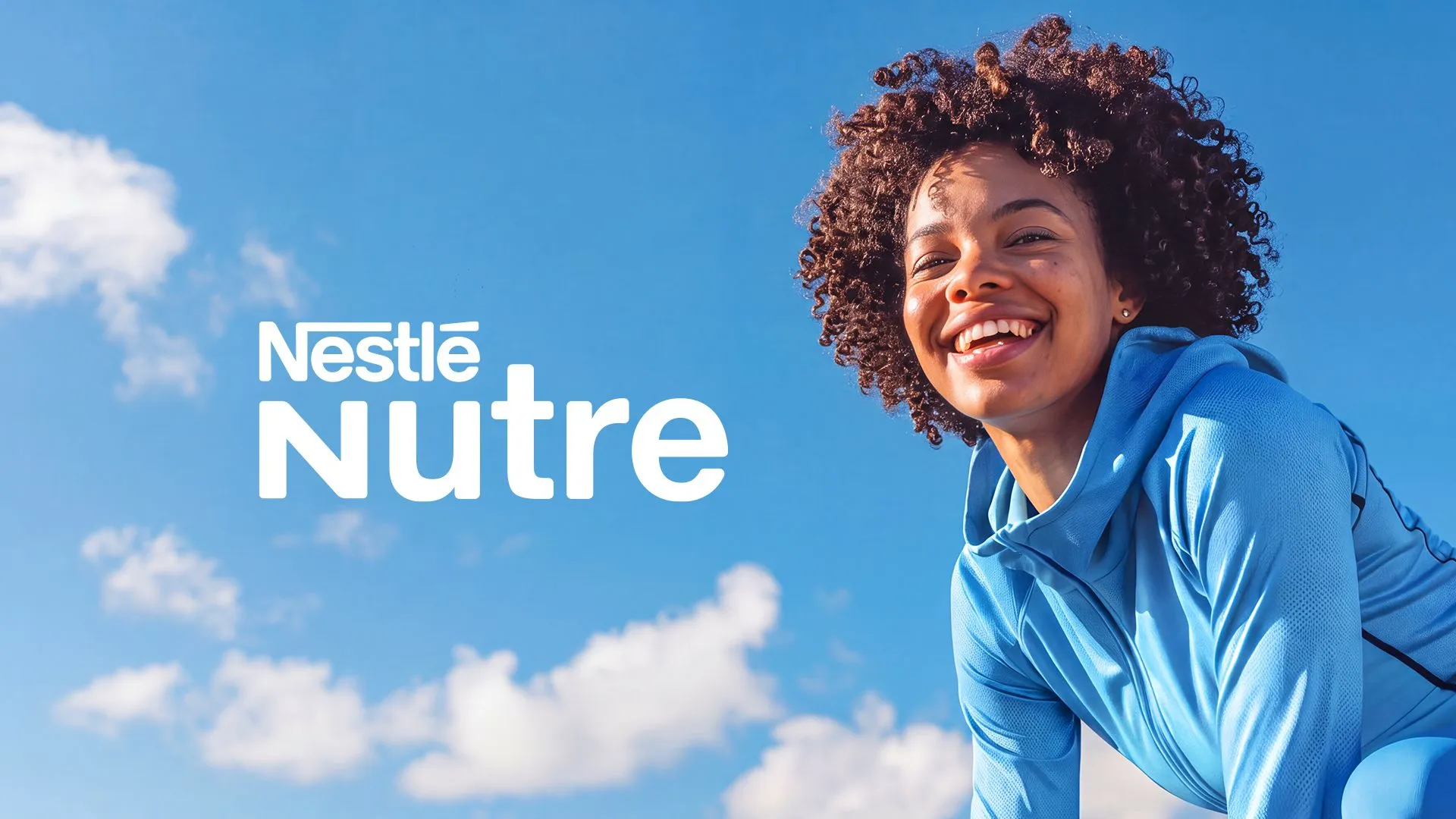Nestlé Nutre Mulher sorrindo de jaqueta azul contra o céu, com o logotipo Nestlé Nutre em branco