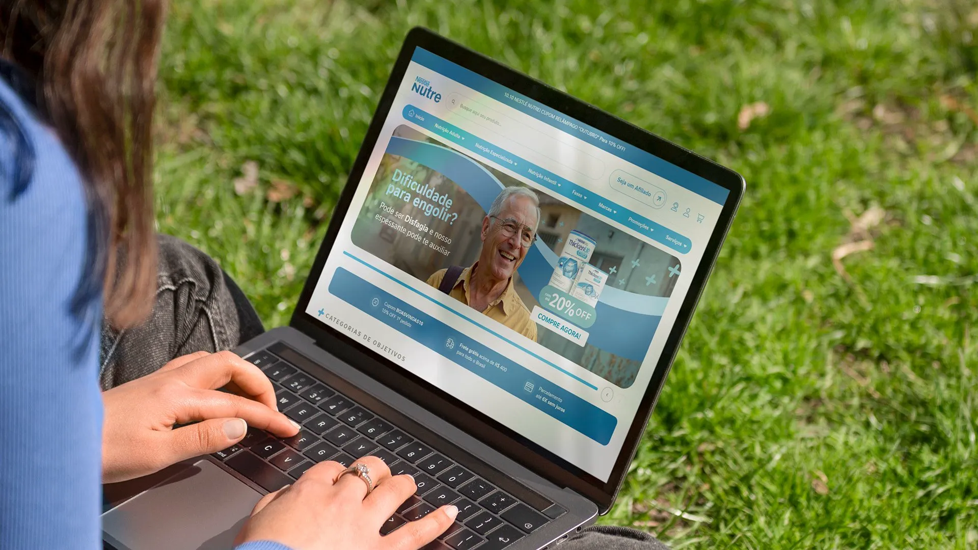 Nestlé Nutre Pessoa sentada na grama usando o site da Nestlé Nutre num notebook